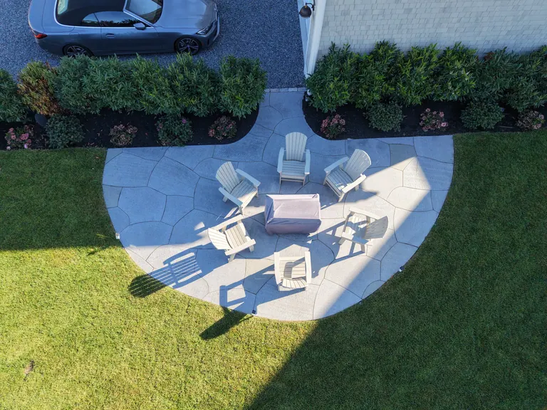 Aerial view of a custom-shaped stone patio installed by Infinity Landscaping