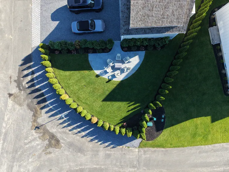 Finished fire pit seating area, lawn and evergreen planting from above
