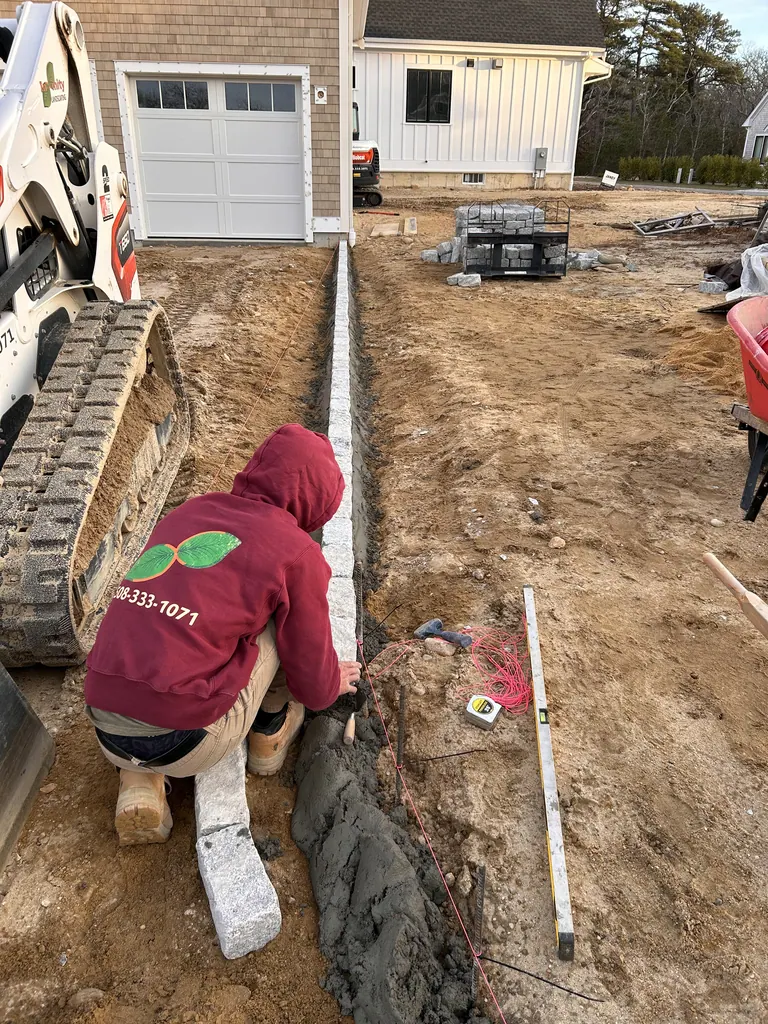 Crew setting stone edging along the driveway