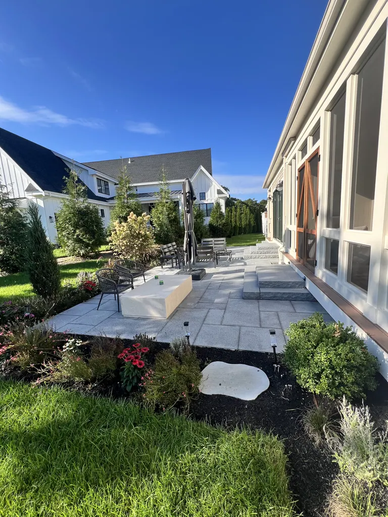 Finished stone patio with entrance steps and garden beds