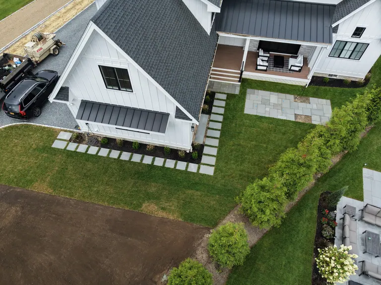Aerial view of the patio and stone walkway around the white house