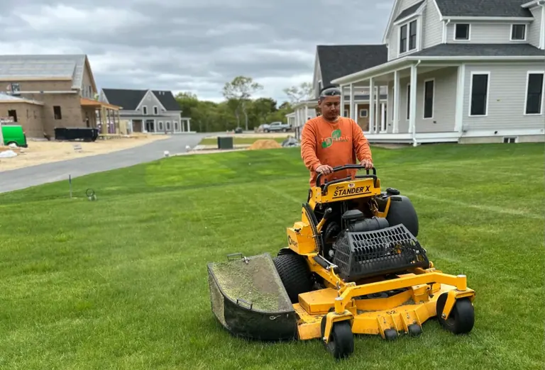 Professional mowing of a healthy lawn beside a Martha's Vineyard home