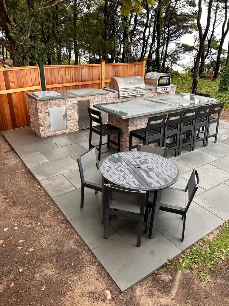 Outdoor kitchen with pizza oven and bluestone dining patio on Martha's Vineyard