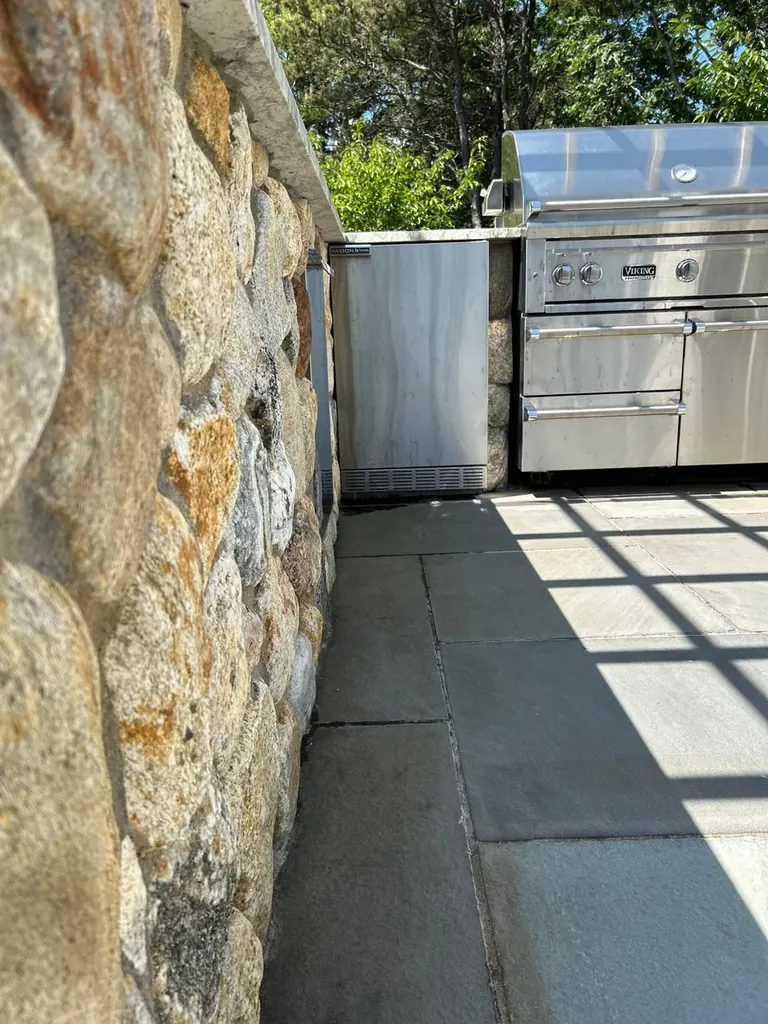 Natural stone veneer wall beside a bluestone patio on Martha's Vineyard