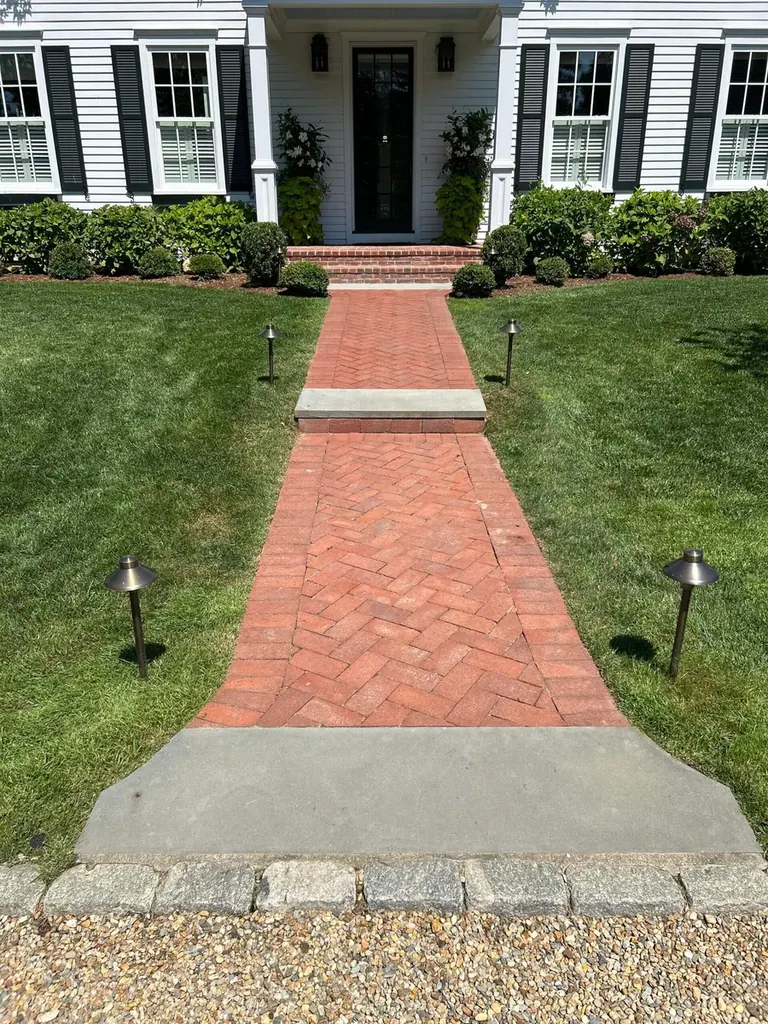 Brick walkway with path lighting leading to a Martha's Vineyard home