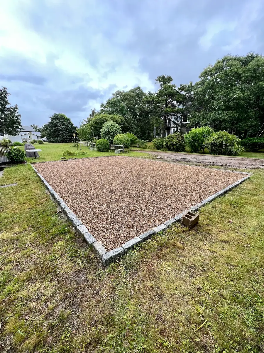 Gravel parking pad bordered with granite cobblestones