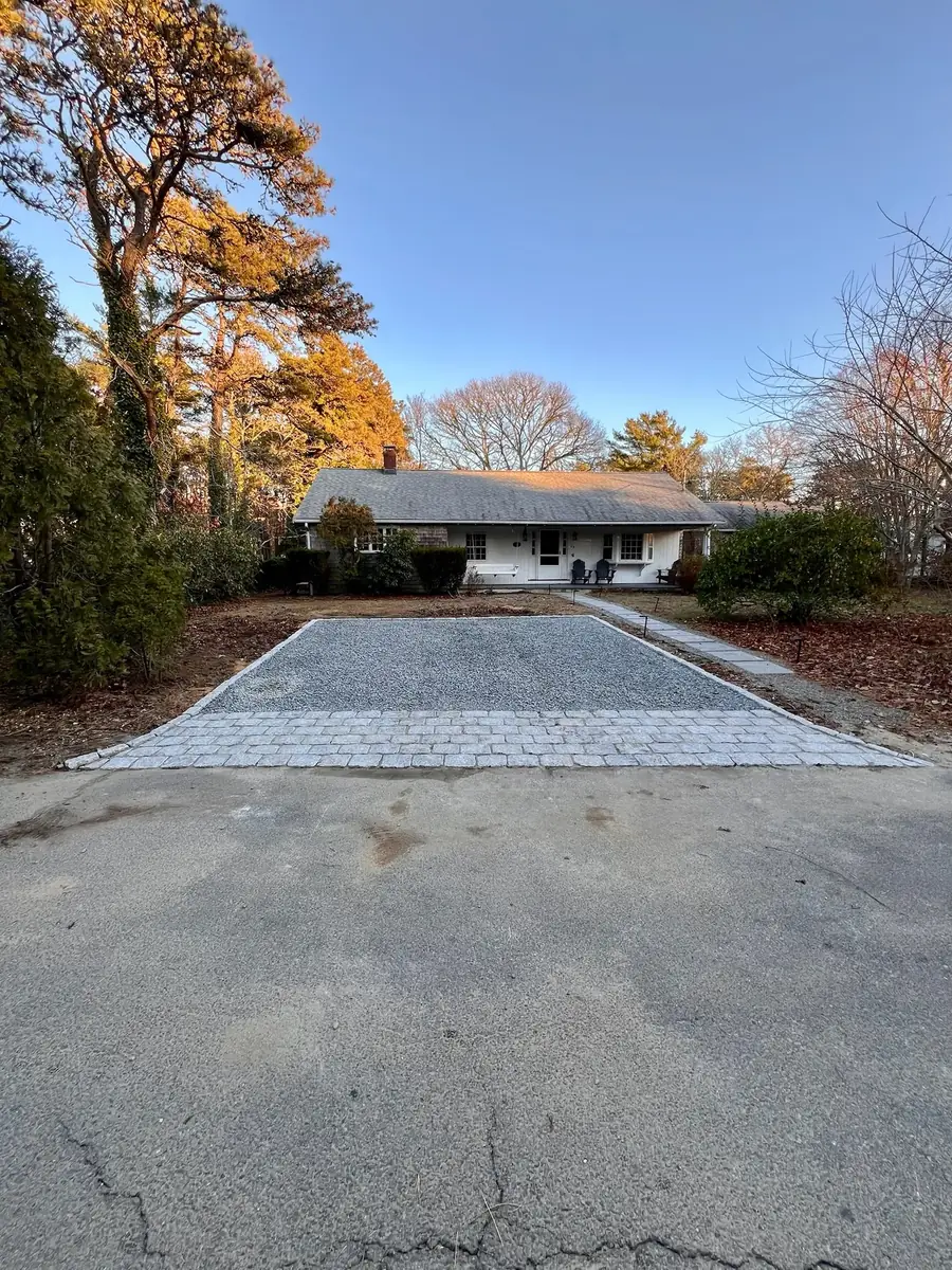 Finished granite cobblestone apron at a ranch house driveway in fall