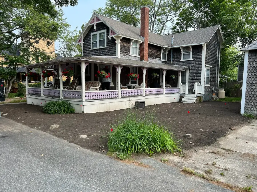 Graded and prepared front yard ready for sod at a cottage with a wraparound porch