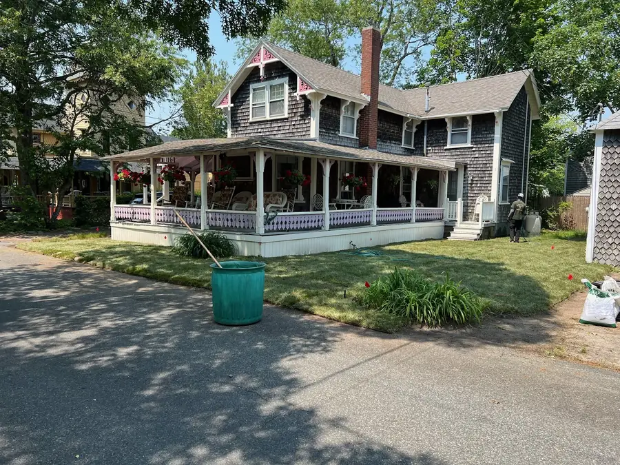 Finished sod lawn in front of a cottage with a wraparound porch