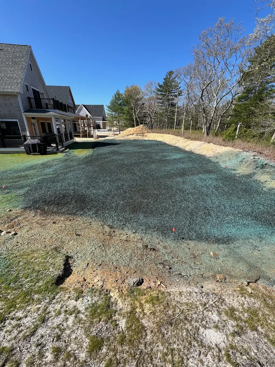 Freshly hydroseeded lawn area with green mulch at a new home
