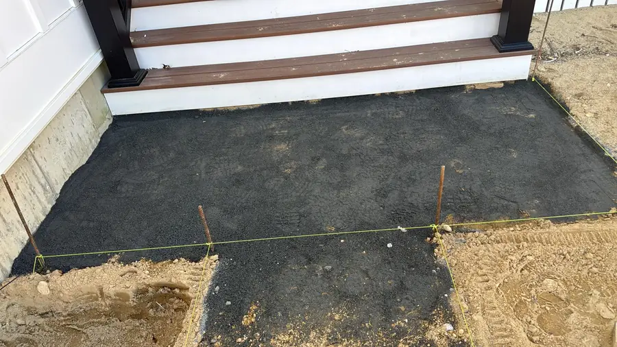 Excavated patio area with a compacted base prepared beside porch steps