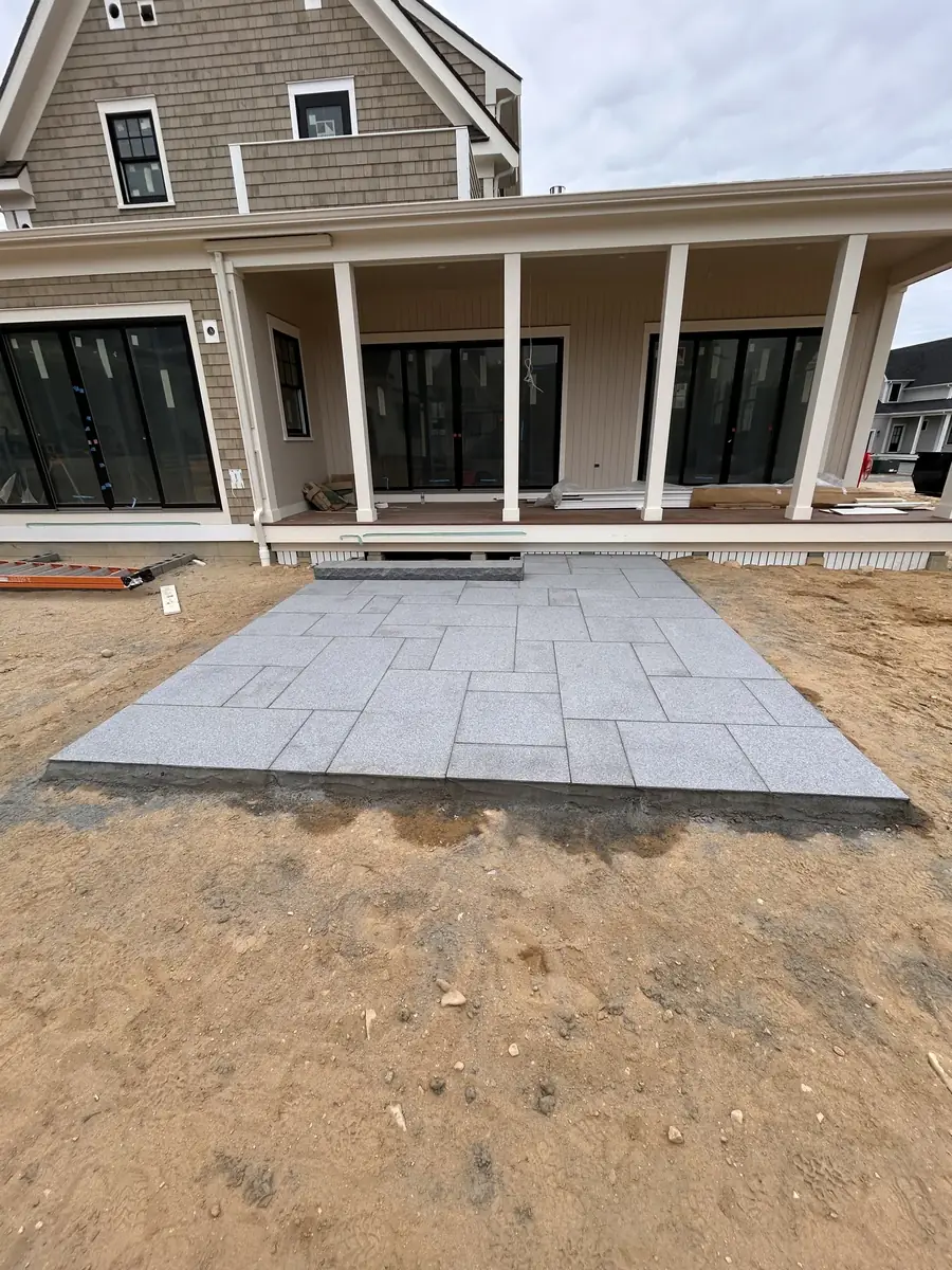 Finished bluestone patio at the porch steps of a new home