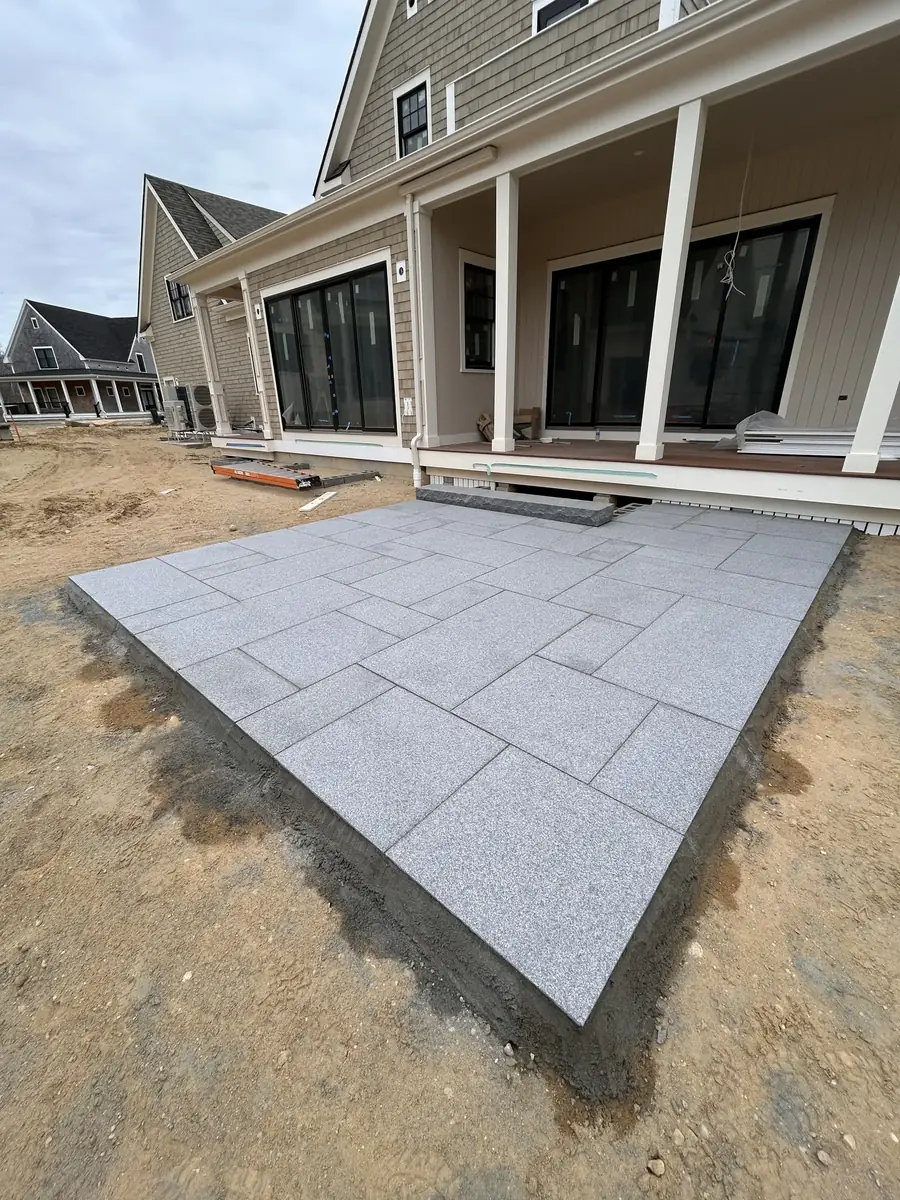 Rectangular pattern bluestone patio with a clean edge beside a new shingled home