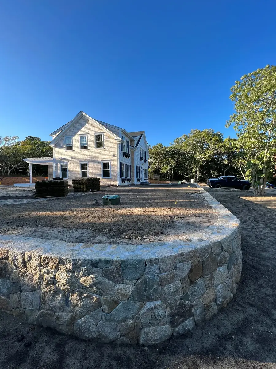 Close view of a curved fieldstone terrace wall with a flat stone cap