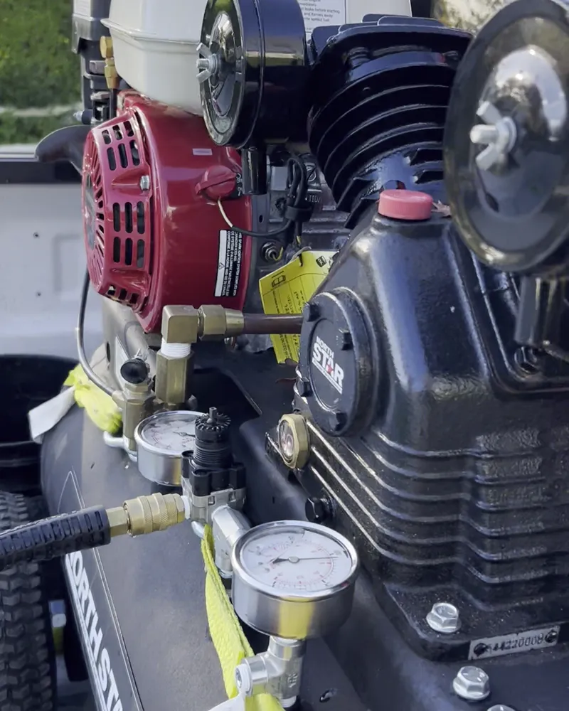 Air compressor with pressure gauges on the crew truck, used to blow out the sprinkler lines