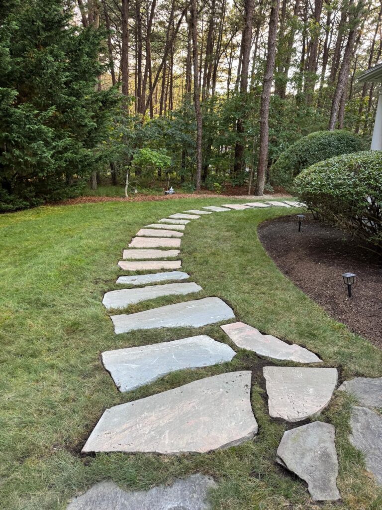 Curved stepping stone installation creating a flowing garden path on Martha’s Vineyard