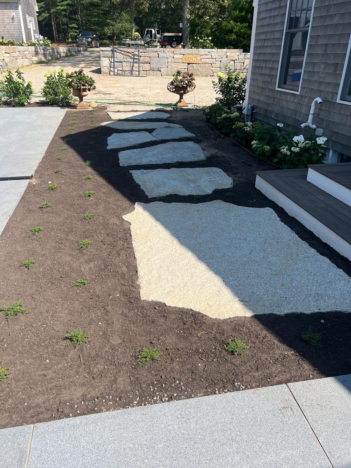 Granite stepping stone installation creating a custom landscape path on Martha’s Vineyard