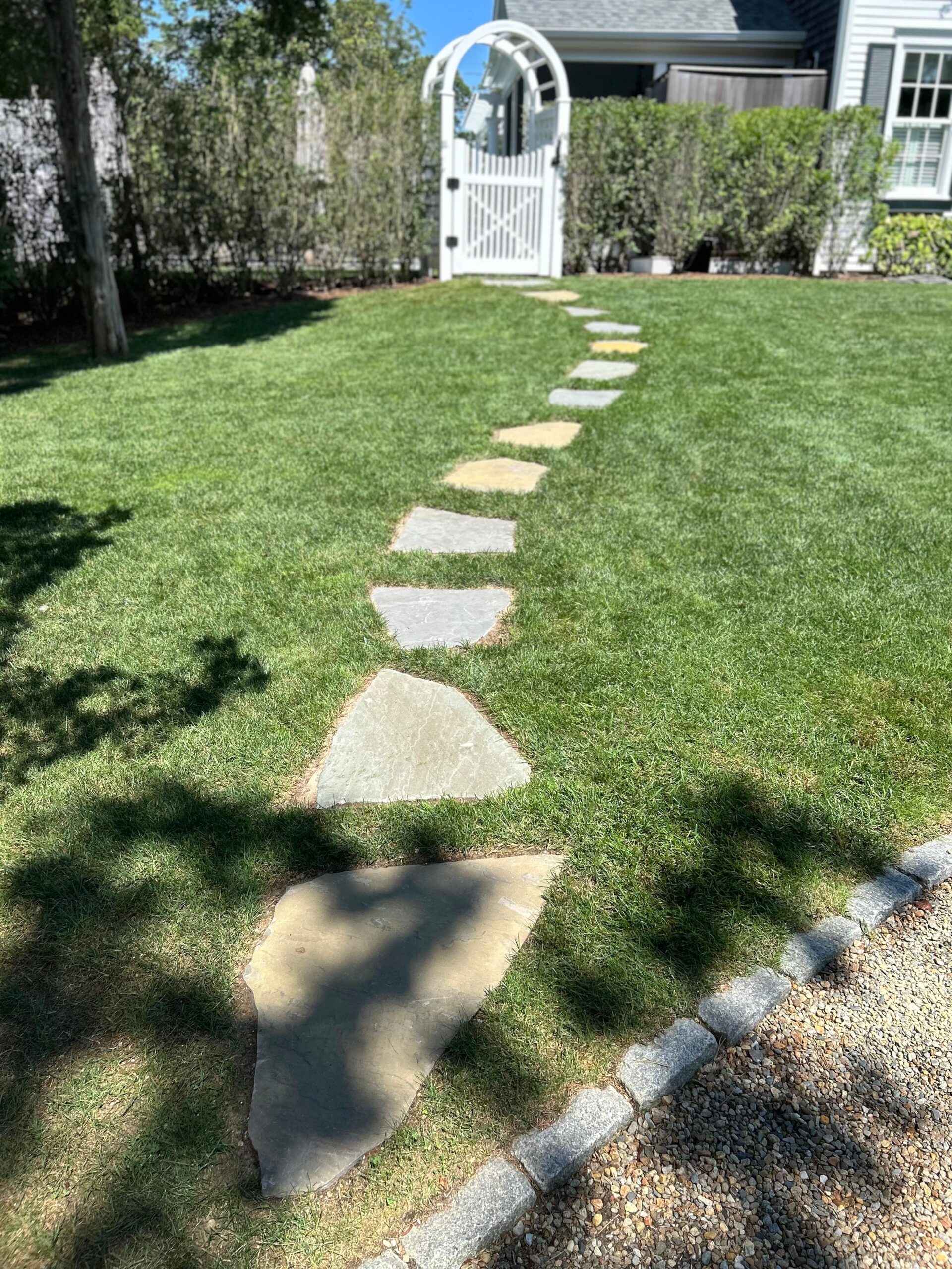 Natural stone stepping stones installed flush with lawn on Martha’s Vineyard