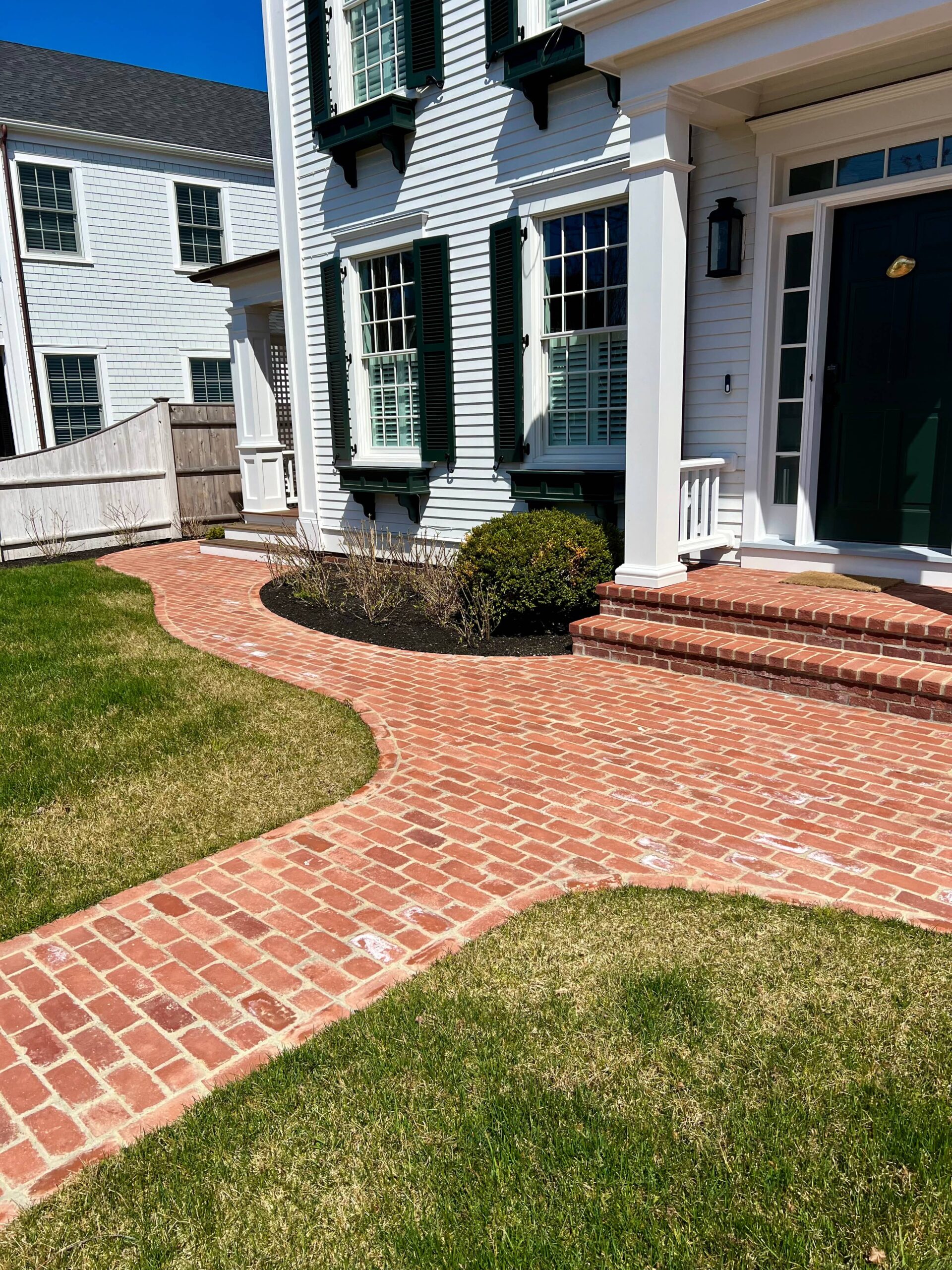 Custom brick walkway installation leading to a front entry on a Martha’s Vineyard property
