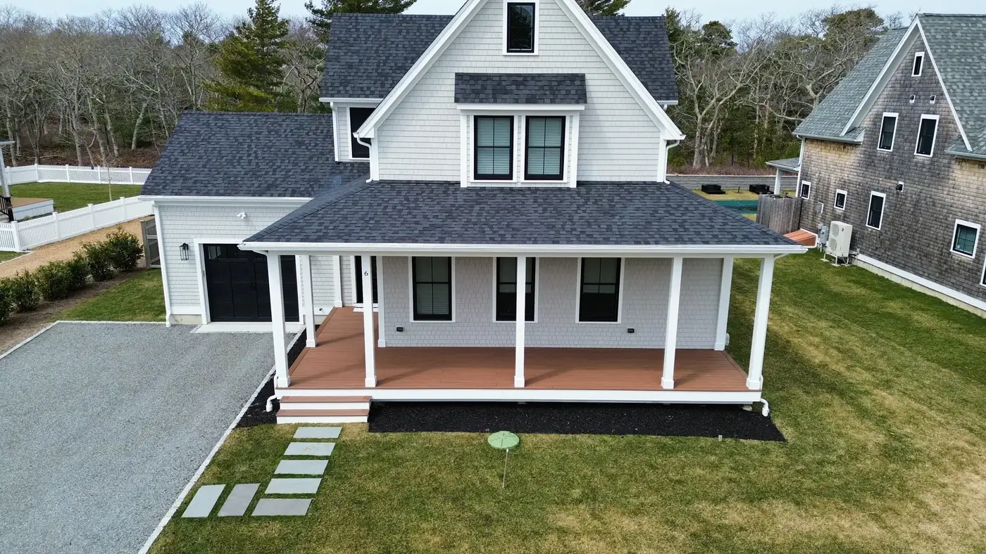 Aerial view of a farmhouse with lawn, planting beds and stone steppers
