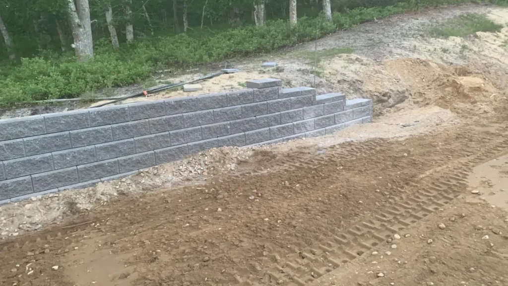 New block retaining wall with backfill behind it on a sloped lot