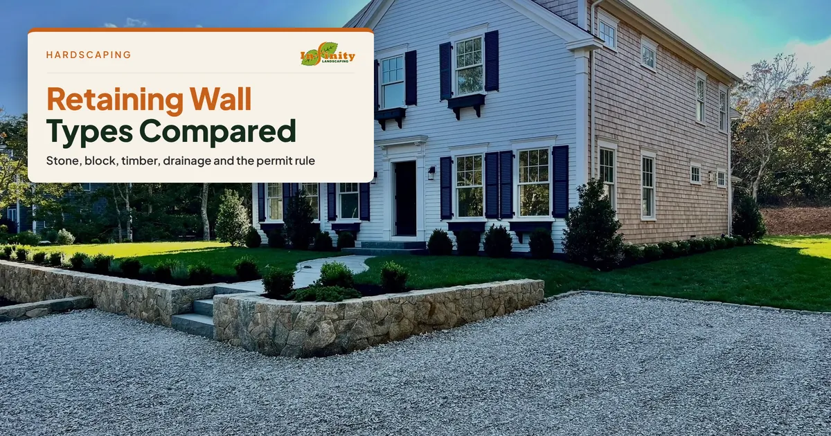 Granite stone retaining wall along a gravel drive at a white colonial house