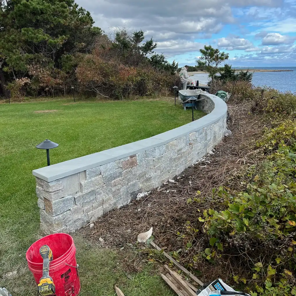 Stone wall along a coastal bluff lawn above the ocean